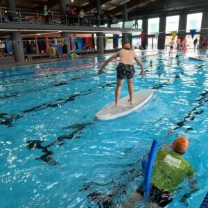 Voluntarios y participantes con diversidad funcional disfrutando de una jornada de acuática de surf adaptado en Cornellà, organizada por SUPerando dentro del programa Tothom a l’aigua