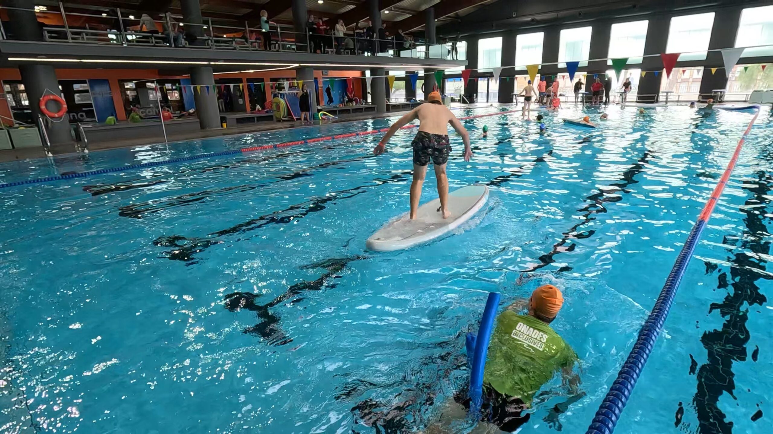 Voluntarios y participantes con diversidad funcional disfrutando de una jornada de acuática de surf adaptado en Cornellà, organizada por SUPerando dentro del programa Tothom a l’aigua