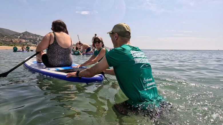 Voluntariado corporativo inclusivo en el mar con empleados de Almirall acompañando a participante de Fundación Mas Albornà junto a SUPerando en Port Ginesta