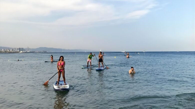 Grupo de personas disfrutando de una actividad de paddle surf inclusivo en el mar en Barcelona con SUPerando