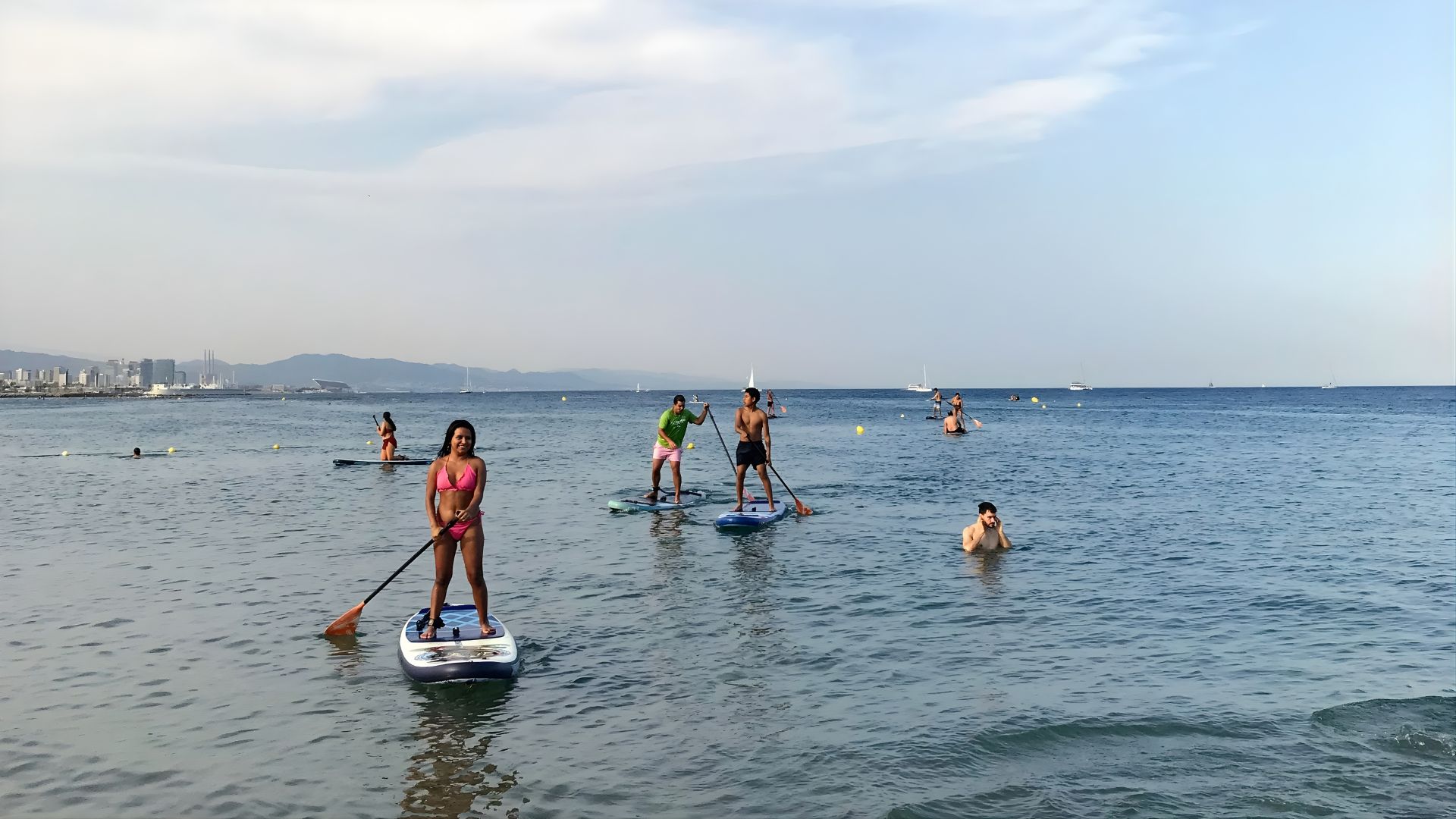 Grupo de personas disfrutando de una actividad de paddle surf inclusivo en el mar en Barcelona con SUPerando